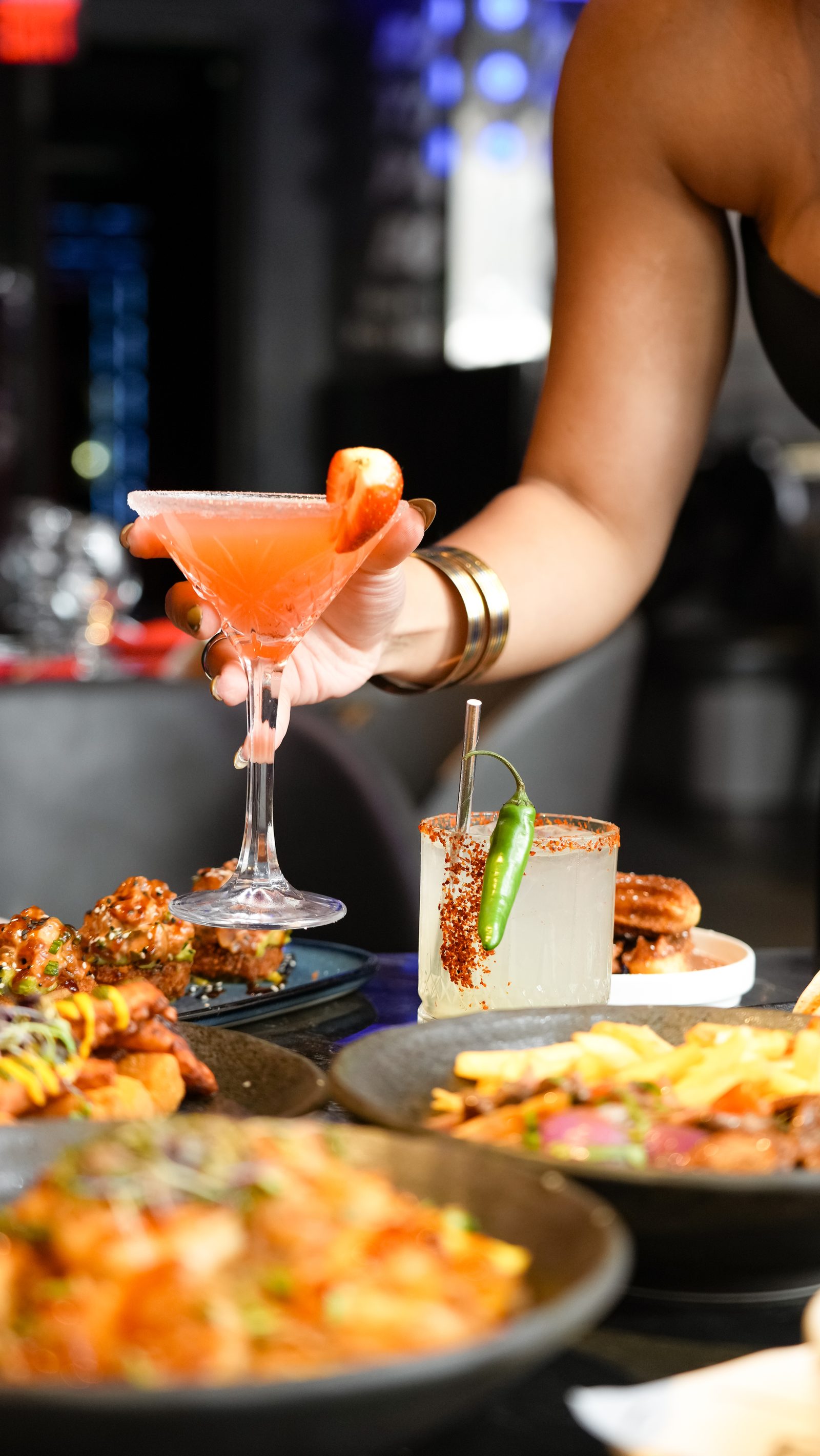 Cocktails and shared plates across a lounge table at IKON