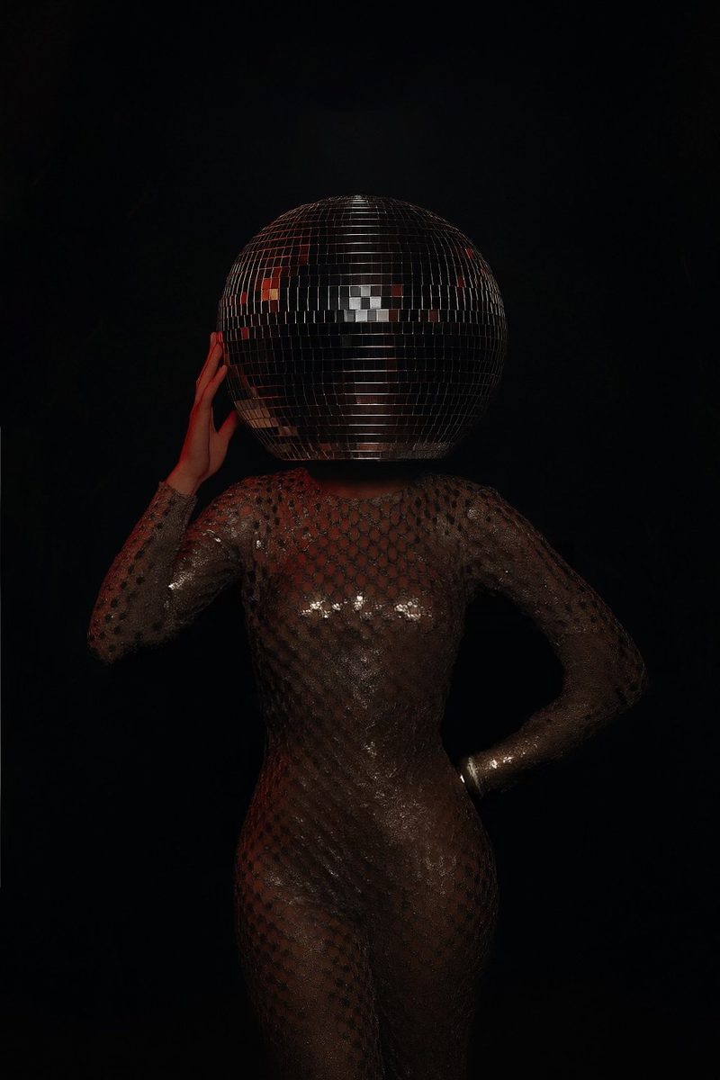 A guest holding a mirrored disco ball in front of her face