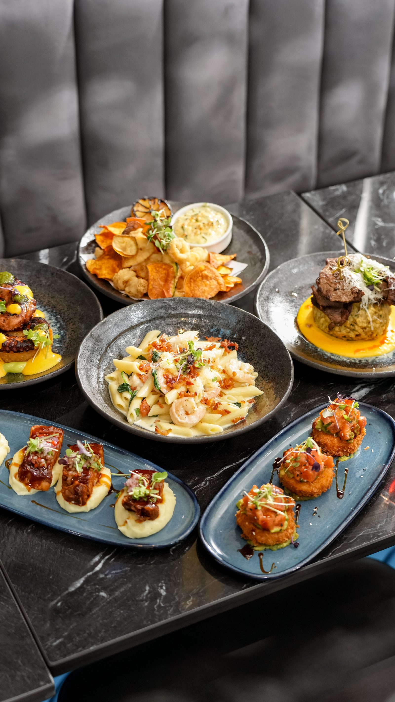 Three plated dishes on dark stoneware at IKON
